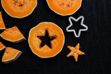 pieces of fresh raw pumpkin on a black background - cut out a star