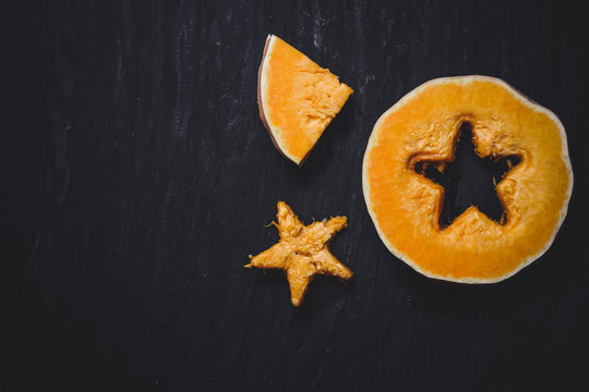 pieces of fresh raw pumpkin on a black background - cut out a star