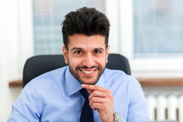 Handsome businessman at his desk in the office