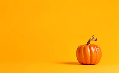 Gordijnen Halloween pumpkin decorations on a yellow-orange background © Tierney