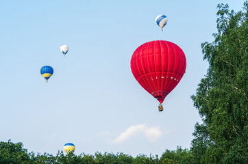 Naklejka premium Balloons fly over the trees