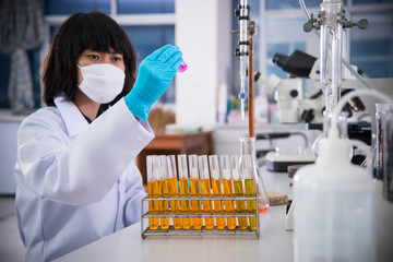Women Scientist checking test sample with test tube