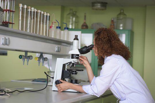 Side view of teenage girl practicing experiment while using