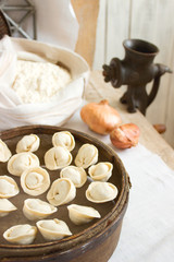 Fototapeta premium Traditional pelmeni or dumpling at cutting board. Homemade preparation food.
