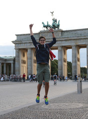 Obraz premium young boy makes a big leap in the Berlin square in front of the