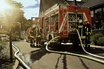 Feuerwehreinsatz mit Feuerwehrleuten und Feuerwehrfahrzeug