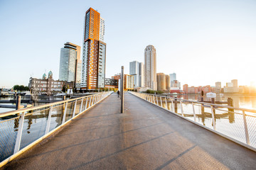 Obraz premium Cityscape view on the modern district with beautiful skyscrapers at the Rijn port during the morning in Rotterdam