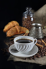 Still life with a porcelain cup of coffee and croissants in a retro style