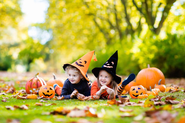 Kids with pumpkins in Halloween costumes