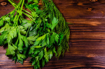 Bunch of parsley and dill on wooden table. Top view