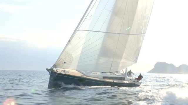 Sailing boat navigating fast in the sea with open sails.