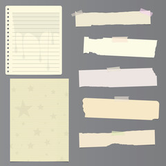 Set of notebook paper sheets - ruled, with leaking paint design, stars and ripped pieces of blank paper on grey background with sticky tape 