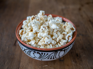 Popcorn in a bowl on a wood table background
