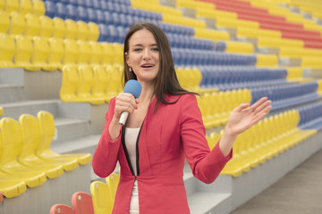 Pretty journalist is reporting from the stadium for television