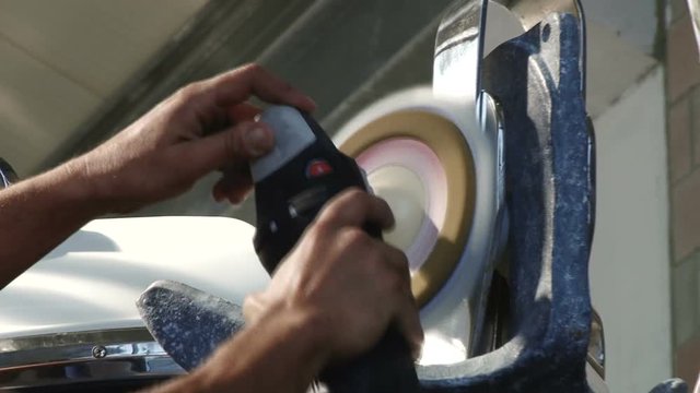 Worker polishing bow of a luxury boat.