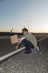 Young man with empty piece of cardboard  hitchhiking © payamona