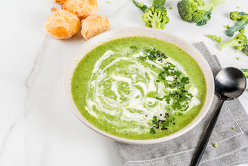 Vegan diet food. Broccoli cream soup, with cheese rolls, greens, on a white marble table. Copy space