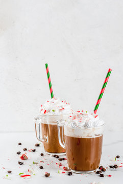 Homemade Peppermint Mocha, Christmas coffee drink with candy canes, whipped cream and mint syrup , on white marble table, copy space