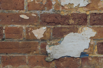 old brick wall with broken plaster