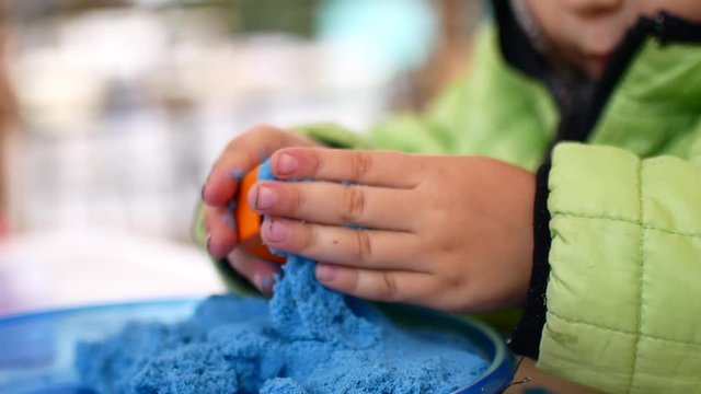The child is played with kinetic sand.