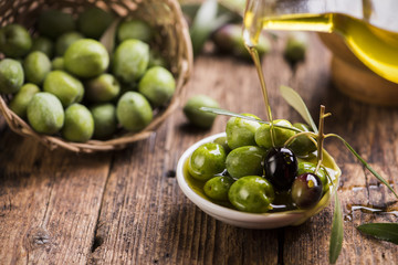 Bottle pouring virgin olive oil in a bowl close up