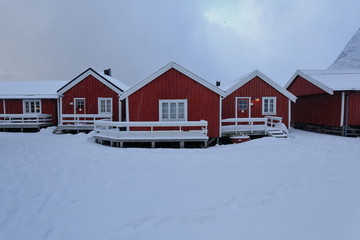 Tourist rorbuer-traditional fishing cottages. Festhaeltinden mounts across Reinefjorden. Hamnoy-Reine-Moskenesoya-Lofoten-Norway. 0368-2