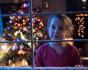 On Christmas night a lovely little girl looking out the window