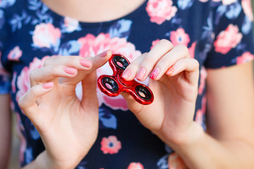 A girl is holding a popular toy fidget spinner in her hands. Stress relief. Anti stress and...
