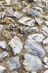 Path - wall built of gray stone and mortar; background, texture.