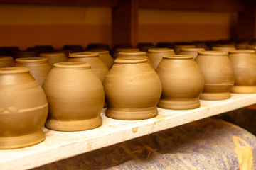 Fototapeta na wymiar A pottery. Pots and jars without a pattern are on the shelves.