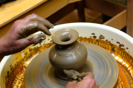 A pottery. Master on the circle makes a vase of clay.