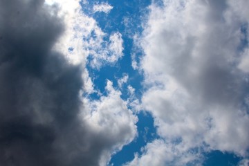 The white and dark clouds in the blue sky.