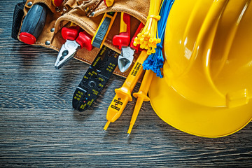 Building helmet leather tool belt on wooden board electricity co