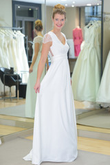 Naklejka premium youn happy bride looked at her wedding dress