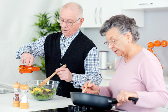 senior couple cooking in kitchen