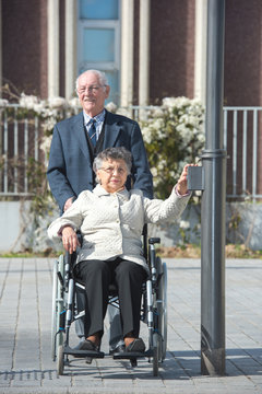 smiling senior man and his wife in a wheelchair