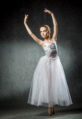 Fototapeta na wymiar Young and incredibly beautiful ballerina posing and dancing in the studio.