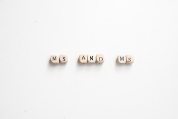 Rustic wooden alphabet blocks spelling MS AND MS on white background from above - marriage equality...