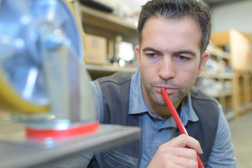 thinking worker with pencil at mouth