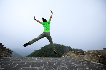 successful woman hiker jumping on great wall