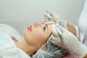Beautiful young girl on the procedure of skin rejuvenation in the beauty salon