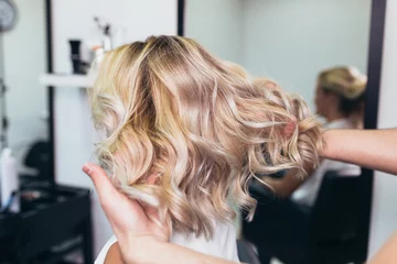Papier Peint photo Salon de coiffure Belle coiffure de jeune femme après avoir teint les cheveux et fait des reflets dans un salon de coiffure.