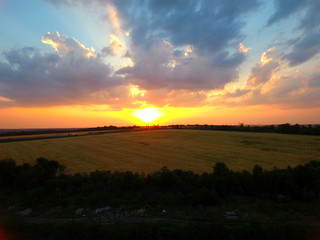 Aerial view of beautiful village, houses, roads. Sky, clouds, sunset.