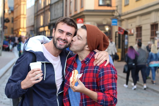 Gay couple passionately kissing on the street