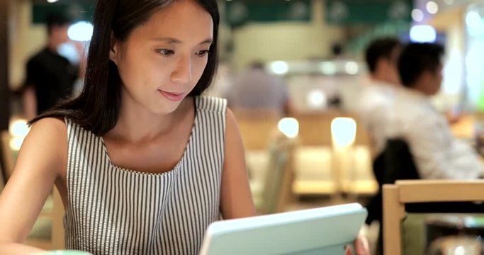 Woman making order on tablet inside Japanese restaurant
