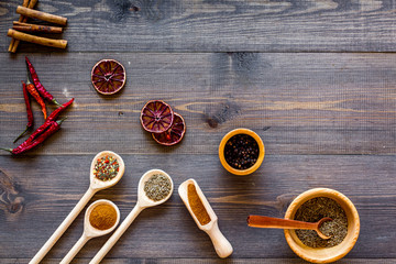 Kitchen table with spices and dry herbs on wooden kitchen background top view mock up