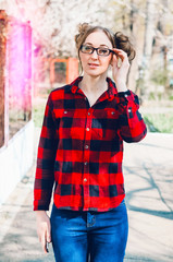 portrait of a girl. stands on the street. sunny day. looks in glasses