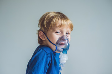 Boy making inhalation with a nebulizer at home
