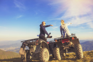 Obraz premium Couple driving off-road with quad bike or ATV
