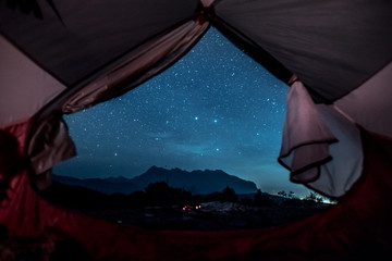 Romantic starry sky night view from inside of tent.  Camp with spectacular starry sky wtih mountain background.